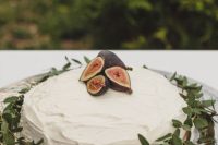 rock a gorgeous white textural wedding cake with greenery and fresh figs on top