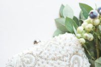 a beautiful pearly and bead embroidered clutch is classics for a modern glam bride