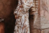 a bold boho nude lace wedding dress with a plunging neckline, long sleeves and a train plus statement accessories