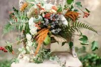 a bold woodland boho wedding bouquet with white roses, berries, leaves, colorful foliage and cascading touches