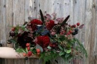 a chic Halloween bouquet with dark burgundy and red blooms and lots of berries that bring interest and texture
