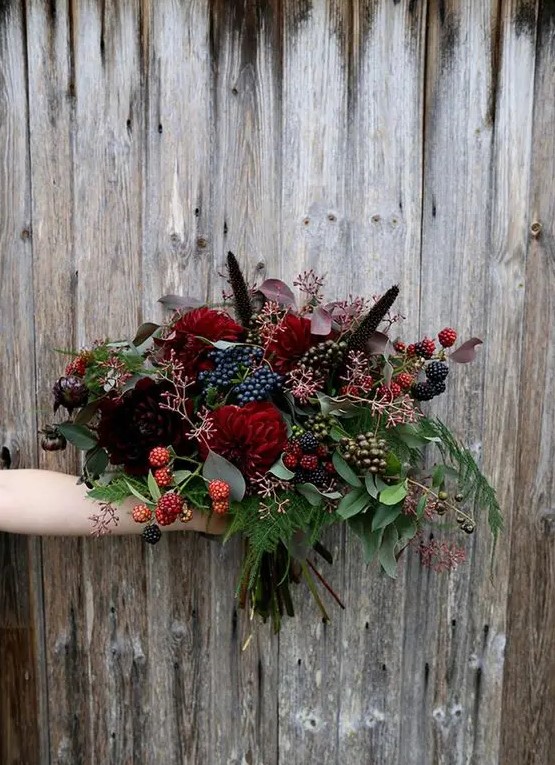 a chic Halloween bouquet with dark burgundy and red blooms and lots of berries that bring interest and texture