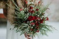 a chic and simple winter wedding bouquet of evergreens and greenery, baby’s breath and red roses