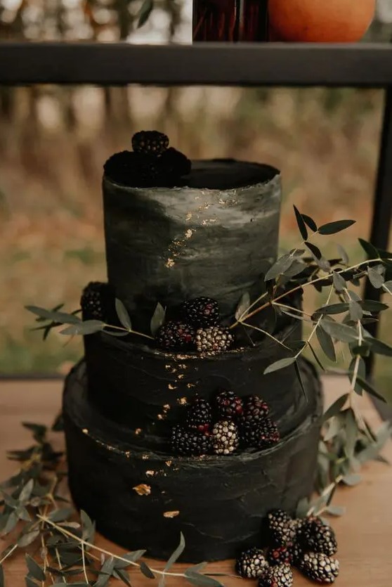 a chic and stylish black textural wedding cake with an ombre touch, gold leaf, blackberries and greenery for a Halloween wedding