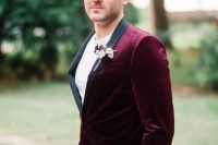 a chic groom’s look with a burgundy velvet tux with black lapels and black pants calmed down with a white tee