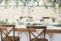 a chic overhead decoration of greenery, air plants and neutral roses and a matching runner