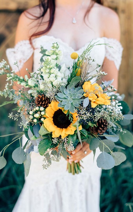 a creative summer wedding bouquet with woodland and farmhouse touches - with succulents, sunflowers, pinecones and billy balls is cool