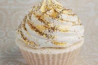 a cupcake with gold glitter on top is a lovely glam idea to rock at a NYE wedding and it will bring some fun