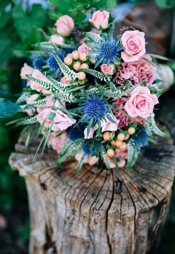 a cute bouquet with blue thistles, soft pink garden roses and some greenery for a sweet summer look