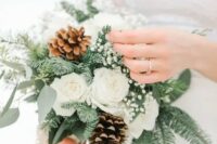 a delicately and lovely winter wedding bouquet of white roses, baby’s breath, evergreens and eucalyptus is an amazing winter idea