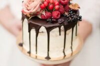 a dreamy fall wedding cake with chocolate drip, fresh berries, a pink rose and a pink candied pear is amazing and mouth-watering