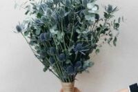 a fabulous wedding bouquet of eucalyptus and blue thistles is a stylish idea for a non-floral minimalist wedding