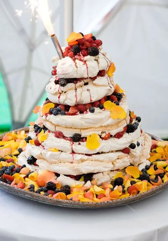 a fantastic pavlova wedding cake with bright petals on top, bold fresh berries is a gorgeous and fun idea for a summer wedding