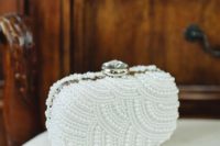 a glam pearl clad clutch with a large rhinestone on top is a chic statement piece for a bride