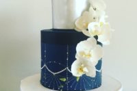 a gorgeous navy and silver wedding cake with embellishments and white sugar orchids is a stunning idea for a modern glam wedding