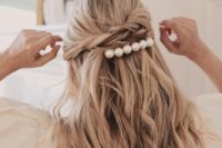 a half updo with twists, a bump and loose waves and accented with a large pearl hair barrette for a casual yet girly look