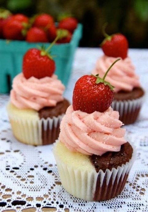a half vanilla and half chocolate cupcake with strawberry frosting and a fresh strawberry is a gorgeous combo