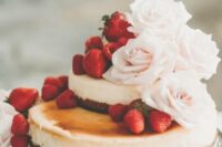 a lovely two-tier wedding cheesecake with fresh strawberries and blush roses is a very beautiful idea to try