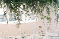 a lush greenery and white bloom wedding installation over the reception table for a refreshing spring feel
