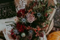a lush moody bridal bouquet with burgundy, blush, rust blooms, lots of greenery and blue thistles