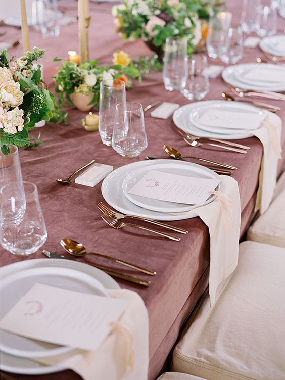 a mauve tablecloth, blush and yellow blooms and copper cutlery for a refined and delicate tablescape