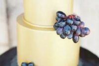 a mellow yellow buttercream wedding cake topped with grapes is a stylish idea for a vineyard wedding, and grapes hint at the location