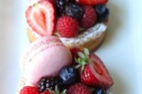 a mini tartlet with custard, fresh berries of various kinds and mini strawberry macarons are gorgeous