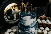 a navy and white marble wedding cake with star and moon toppers is a fun and bold idea with a touch of glam