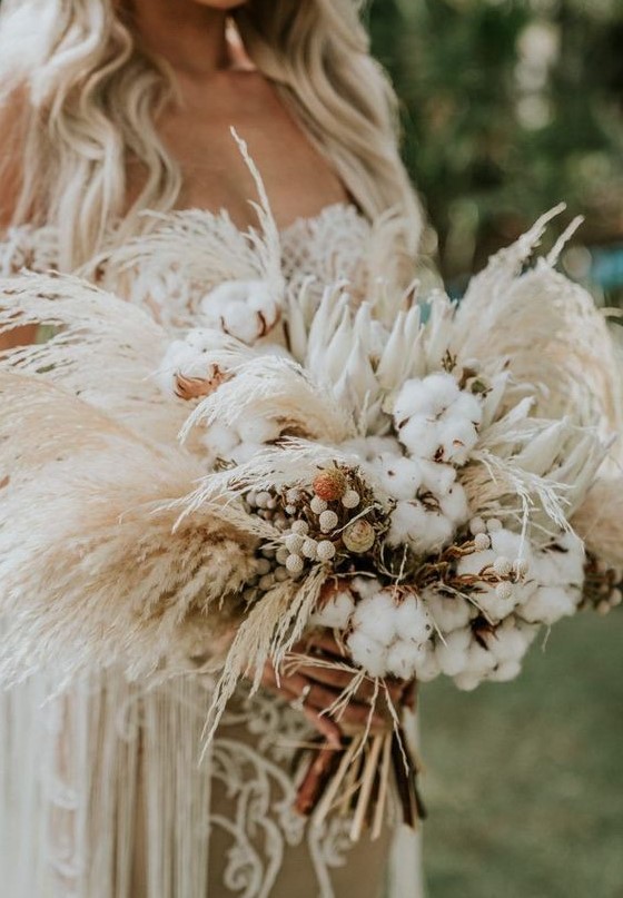 a neutral boho wedding bouquet of cotton, white proteas, berries, pampas grass and spikes