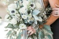 a neutral spring wedding bouquet with white blooms, pale greenery, berries and blooming branches