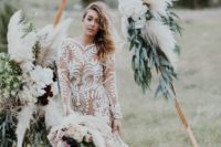 a nude boho wedding dress with white lace, a mermaid silhouette, long sleeves and a train
