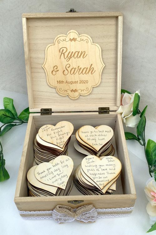 a plywood box filled with plywood hearts that are to be signed by the guests and accented with a burlap ribbon
