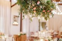 a romantic overhead decoration of greenery, hydrangeas, pink roses and candle holders