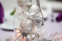 a shining winter wedding centerpiece of a wreath with silver snowflakes and a vase with silver ornaments