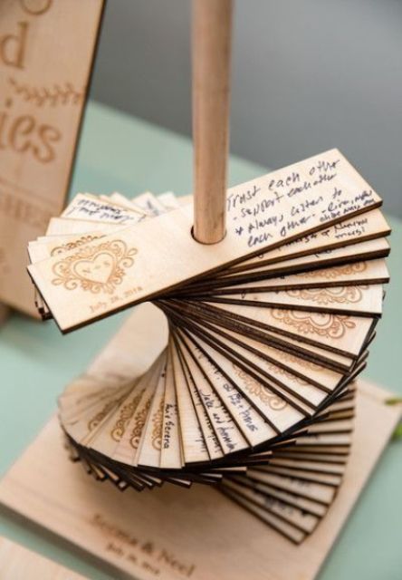 a stand with thin plywood pieces and names and a date burnt on them is a creative and cool wedding guest book