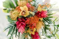 a super bold tropical wedding bouquet with yellow orchids, a cascade and much greenery for a bold and vibrant statement