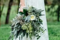 a textural and catchy greenery wedding bouquet including various types of eucalyptus and large white blooms and herbs