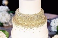 a white and gold polka dot wedding cake with a gold calligraphy topper is a lovely glam wedding piece to enjoy