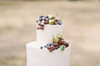 a white buttercream wedding cake topped with gilded mini pears, blueberries and grapes and some foliage is a very cool idea for a vineyard wedding