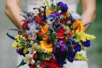 a wildflower wedding bouquet with red, yellow, orange, purple, lavender and greenery for a bold look