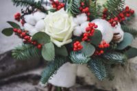 a winter wedding bouquet with white roses, cotton, silver ornaments and evergreens is amazing for a winter bride