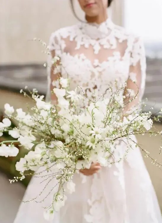 an all-white wedding bouquet of blooming branches is a heavenly beautiful idea for a spring bride