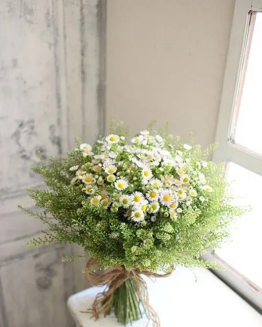 an amazing summer wedding bouquet of daisies and greenery is a very chic and very simple idea for a boho or rustic summer wedding
