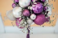 an unusual wedding bouquet composed fully of Christmas ornaments of various shades and silver foliage