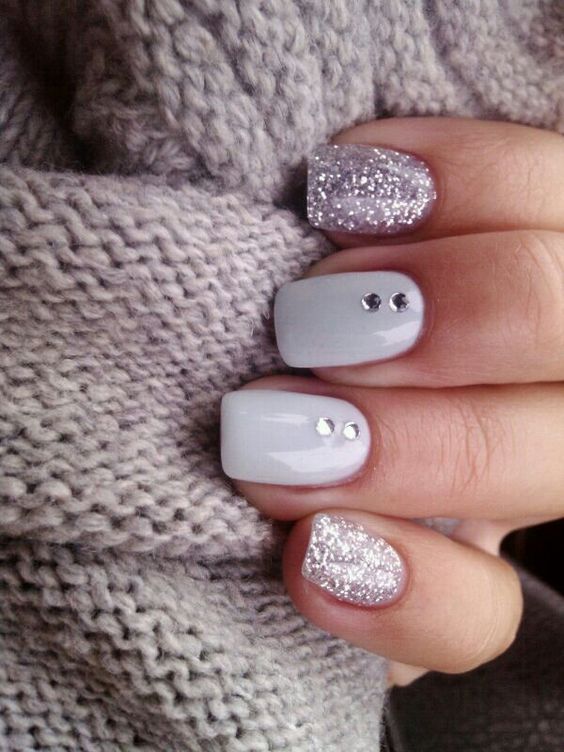 glitter and white nails with two rhinestones on each for a sparkly and glam holiday look