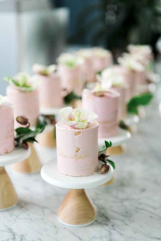 mini pink cakes with sugar blooms on top are tasty and will substitute a usual wedding cake easily