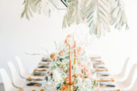 pale and dried leaves and candleholders hanging from above make the reception look bolder and cooler