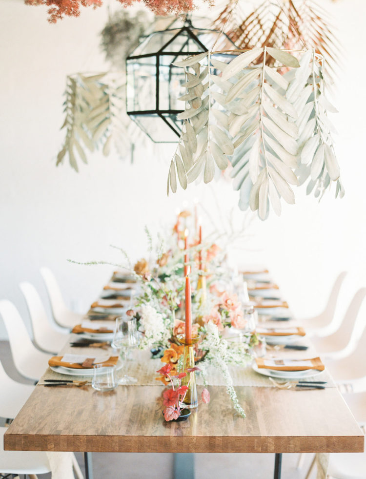 Pale and dried leaves and candleholders hanging from above make the reception look bolder and cooler