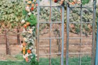 rustic and shabby chic French doors decorated with greenery, blush, yellow and red blooms are a great wedding backdrop