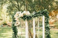 shabby chic French doors decorated with greenery and pastel blooms will be a beautiful wedding backdrop for a garden wedding